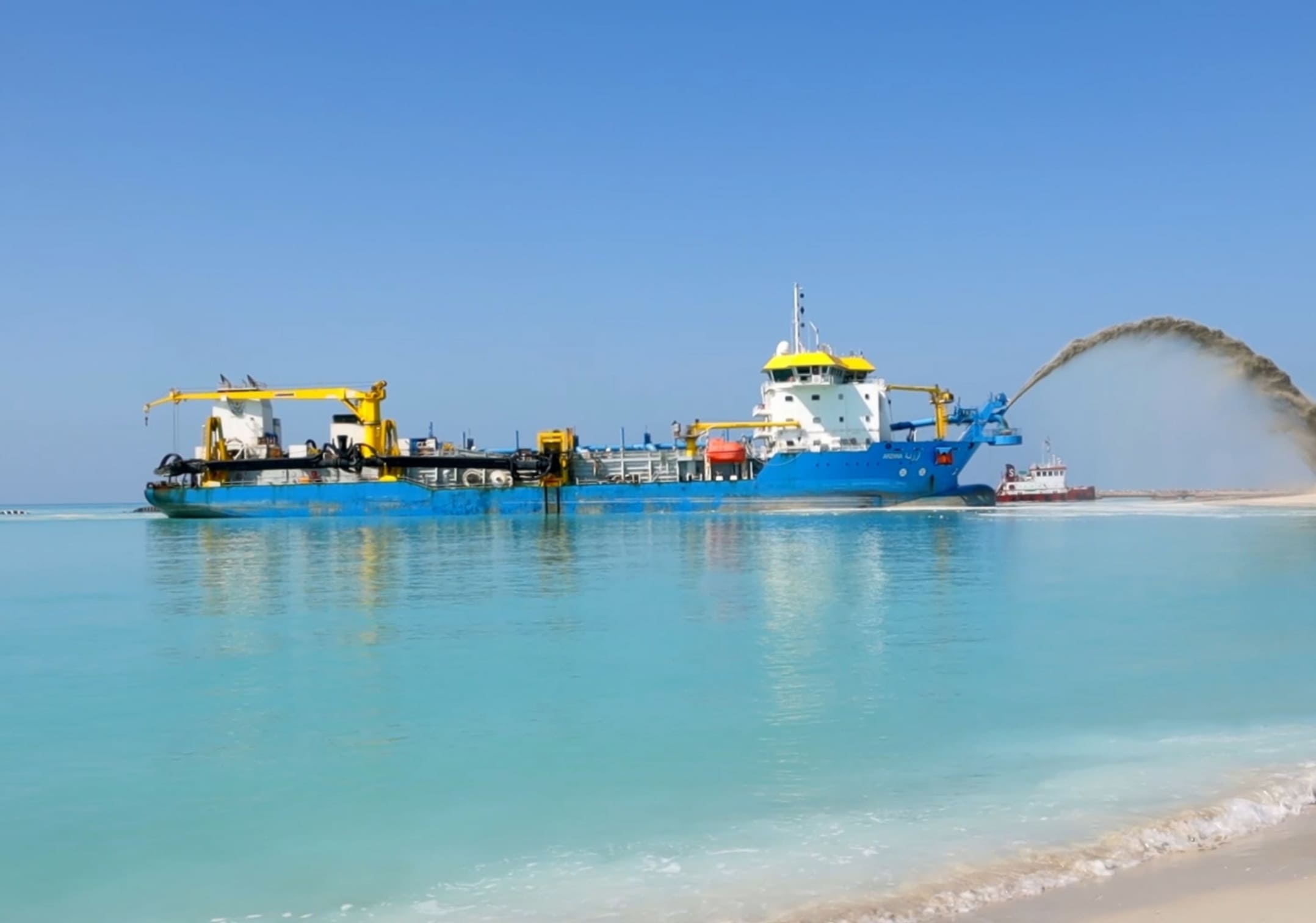 Dredger pumping reclamation material at sea